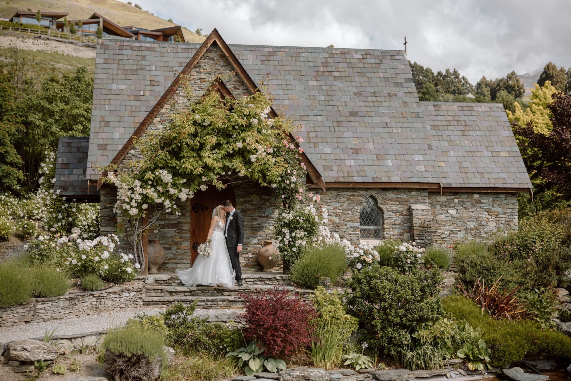 AIC_WB313 Taylor & James kissing by vesty door full Chapel shot